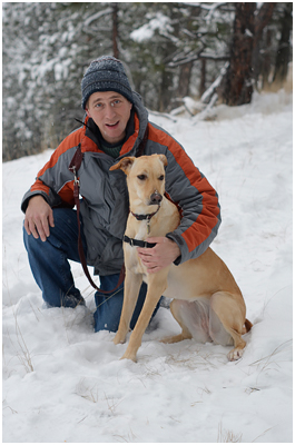 Michael Wieser beside his dog in a snowy forest
